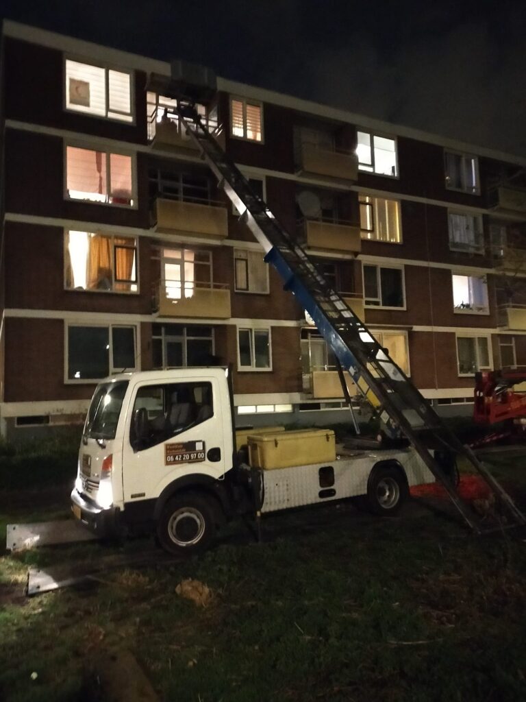 Verhuislift in actie bij appartementencomplex in de avond